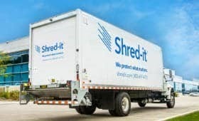 A white truck with blue text on it Description automatically generated